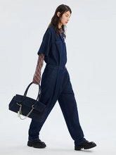 a lady wears a dark blue denim jumpsuit